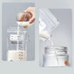 Hand pouring milk from a container into a breast milk storage bag and then into a jar on a light gray background.